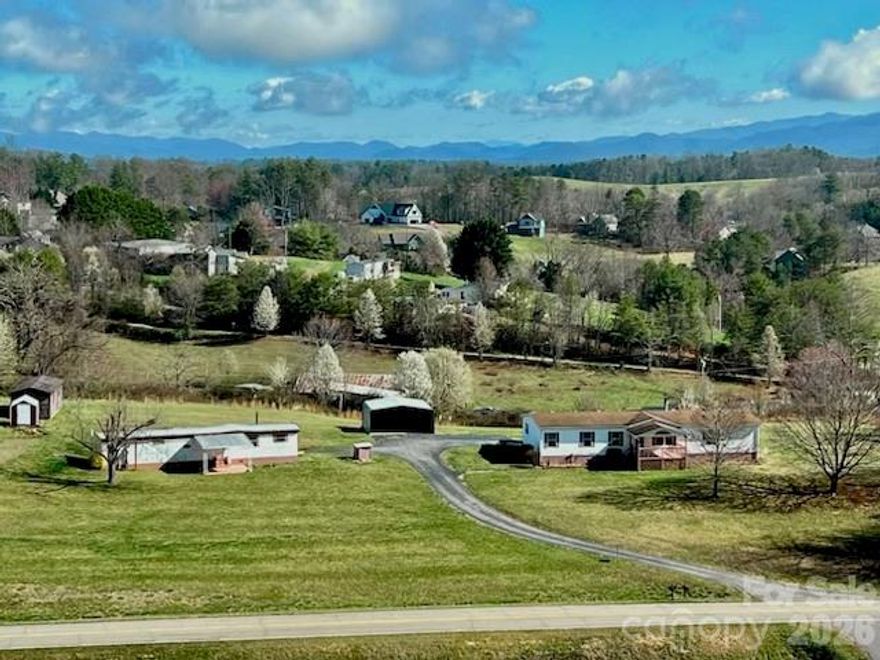 Gorgeous long-range Mountain views from this renovated 4 bedroom, 2 bath home with a carport on 1.99 fairly level acres. This is a fantastic sunny parcel in a terrific location which includes a 2/1, small-single-wide. Updated, beautiful kitchen cabinets, counters, double sink, stainless appliances, updated baths, newer laminate floors throughout. Drywall throughout and newer decking, front and back. Gas fireplace in family room, great open floor plan. Two covered decks and garden space and lots of land for gardening and creating a sanctuary. The lot is totally open and you can research adding other structures. Shared well and driveway for both homes. Each home has a separate PIN but is currently on one deed. There is a separate workshop located on the property. Make this home.