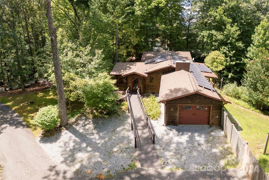 Cozy, mountain cabin home offering one level living within close proximity of Downtown Brevard yet offering mountain get away feel so many desire! Have breakfast in the light filled sunroom! Curl up in front of the wood burning, insert fireplace on a cold winter night in the open concept living room. Reduce energy costs through solar panels & fireplace that puts out heat through FP venting system. Take a jacuzzi bath in the garden tub overlooking the trees & canyon. Appreciate the character of the home with its beautiful wood floors in main living areas, built in bookcases, two back decks, one open air off the bedroom & one covered off the living room, enabling one to bask in the tranquil setting. Enjoy the fenced yard for the pets in your life! Transylvania County offers over 250 waterfalls & home located 20 minutes from Dupont State Park with some of the prettiest scenery in the County! Conveniently located close to town so you can enjoy a night out & be home in less than 15 minutes!