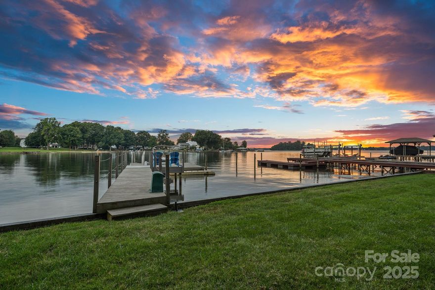 Welcome to your lakeside escape, where every day ends with a sunset! Enjoy long range, main channel Lake Norman views from this eclectic lake house filled with warmth and charm. Perfectly set on a beautifully landscaped, flat lot with a large grassy yard and mature trees. Thoughtfully updated throughout, the home offers the comfort of dual primary suites, one on each level making it easy to host family and friends. The cozy sunroom is the heart of the home, where you’ll want to linger with morning coffee or curl up in the evenings while the lake glimmers outside your window. Step outside and life on the water is yours to enjoy, with a private dock and boat lift ready for endless lake days. Whether it’s boating, entertaining, or simply relaxing under the trees, this property was designed to make every moment feel special. This is more than a lake house—it’s a place where memories are made, laughter is shared, and sunsets are never missed. Newer roof & gutters (2022), HVAC (2018 & 2022).