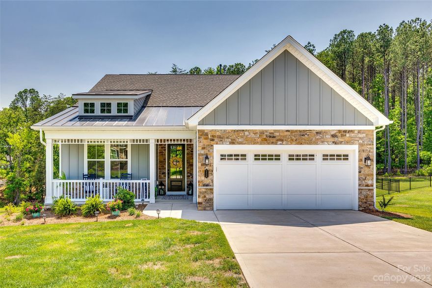 Welcome to Handsmill on Lake Wylie! Don't let this cozy cottage exterior fool you! With over 2100sqft of main level living, and an incredible walk out basement, you may be tempted to call this your vacation home! Lounge on the covered deck with your morning coffee or host an outdoor dinner party. There is room enough for all! The 1/2acre lot is fenced with a completely wooded back drop. Private and serene. Inside, the expansive kitchen is open to the great room and faces the rear outdoor living space. Located just off the garage entry, is the ultimate in convenience. An elevator to transport those heavy items to the second kitchen and rec-room below.  Soaring ceilings and oversized windows add to the bright and airy feel of the lower level. Owner is currently using the theatre room as a fourth bedroom. Plenty of storage options too with walk-in closets and a separate room just for stuff! Handsmill on Lake Wylie offers a clubhouse, pool, playground, & lake access for their residents.