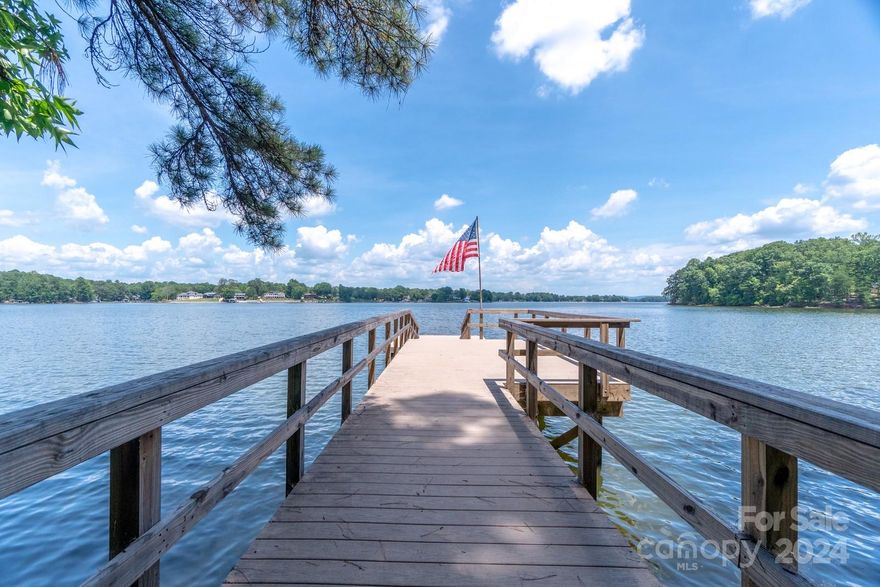 Almost 3 Acres and over 1200 feet of lake frontage. Recently upgraded Dock with Composite decking and your very own private boat ramp.  The lot is wooded but if the under brush were removed and the trees limbed up to about 15 feet you would have more than a 180 degree view of the lake. I don't know of another home on the lake that has over 1200 feet of lake frontage.  This is a private and secluded paradise that would be impossible to duplicate on the lake.  The lot comes with a cute & cozy 2 bedroom, 2 bath cabin that has gorgeous exposed beams with a cathedral ceiling in the great room. There is a covered lakeside gazebo that will entertain 10 to 15 guests for a great picnic/party. As with a lot of areas on High Rock Lake this is in a Flood Fringe area, however, the lake has never flooded and the family has owned this property for 74 years and it has never even come close to flooding. This almost 3 acre level lake paradise could be your new private lake  dream get-a-way.