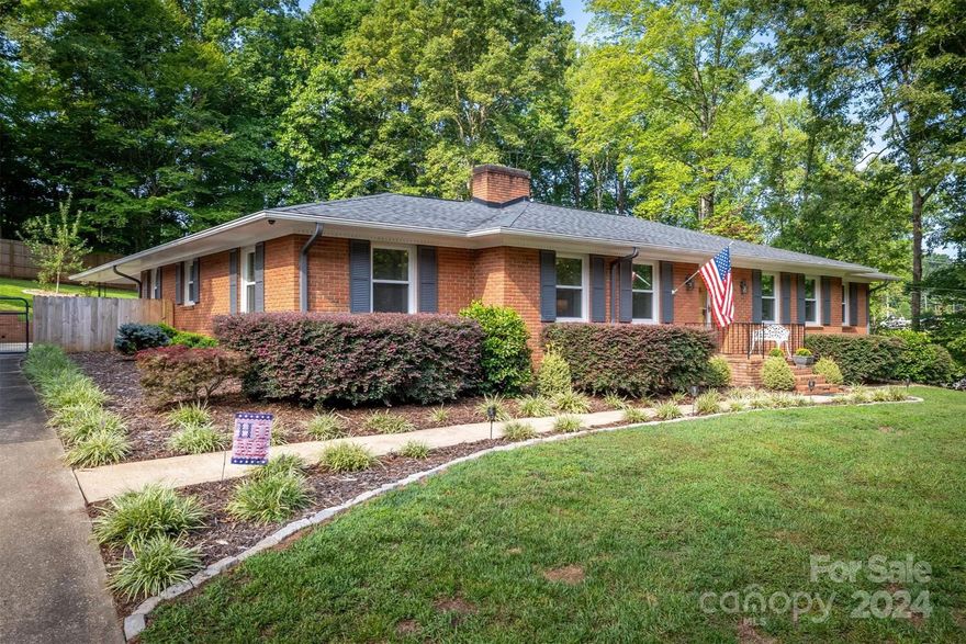 This meticulously maintained brick home is perfectly located near downtown Morganton for easy access to all amenities. Enjoy the comfort of one-level living, complemented by a spacious basement offering both finished and unfinished areas, ideal for storage, a workshop, or future expansion with plumbing ready for an additional bathroom. The home features ceiling fans throughout the main level, two cozy fireplaces, and modern stainless appliances in a stylish kitchen. Outside, the expansive fenced backyard offers privacy and space to entertain on the screened porch and deck. Enjoy the fruit plantings - a peach tree, 2 apple trees, blueberry, blackberry & raspberry bushes! A double carport adds convenience, making this home a perfect blend of charm and functionality.