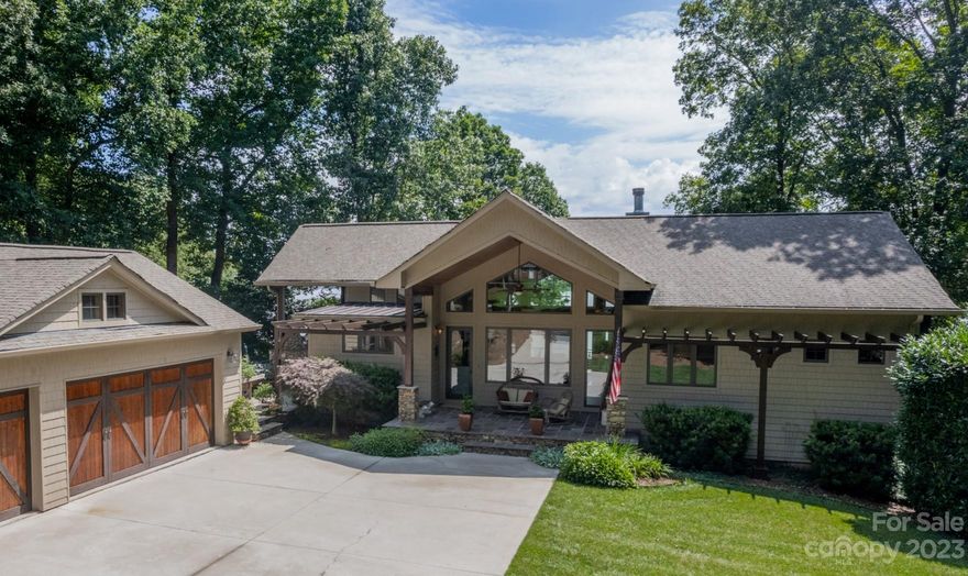 Waterfront Custom-Built Modern Mountain Home boasts 271 feet of Shoreline w/Private Beach, covered boat dock, lift, firepit, grass areas & stunning year round, Big Water Views. Enter through the Front Covered Porch into the Great Room w/Cathedral Ceilings & a wall of windows Front & Back for Exceptional Lighting & Views. Open floor plan moves to dining area & kitchen, both w/Lake views & High Ceilings. Main level Primary Ensuite w/Sitting Room & Fireplace, walk-in closet, built-ins & washer/dryer. Separate Office on main. Lower level walkout basement includes living area, Bar area w/2 beverage fridges, 3 bedrooms, 2 full baths, storage,cork flooring & carpet. Both Upper & Lower levels have Wrap-Around Patios, Upstairs patio has Cathedral Ceilings & includes BBQ & fireplace, Downstairs Wrap around has 4 fans & lots of room for entertaining. Separate living quarters under garage w/its own access & Water Views. Large Workshop. 3 car garage, Whole House Filtration system, Surround Sound.