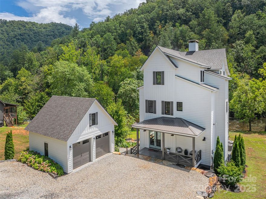 This luxurious modern farmhouse is perfectly situated above the tranquil Tuckasegee River, a fisherman’s dream stocked with trout and perfect for floating or kayaking directly from your backyard. The gently sloping, oversized lot offers one of the most desirable settings in the neighborhood, with a large grassy backyard, no flood damage during Hurricane Helene, and plenty of parking for family and guests. Inside, the home features a spacious open floor plan with beautiful river views from nearly every window. The main level includes a large living room that flows into an elegant kitchen and dining area with a half bath. From here, step onto one of two expansive Trex decks, ideal for lounging and entertaining while overlooking the river. The upper level serves as a true retreat, with a primary bedroom that opens into a spacious office with a sleek wet bar, a private Trex deck, and a spa-like bathroom with a soaking tub and tiled shower. The third floor includes two generous guest bedrooms, each with its own private full bathroom. A Redwood Outdoors 6-person barrel sauna, featuring a powerful 8kW Harvia WiFi-controlled heater and a full glass wall that looks out over the water, creating a private wellness experience. The home also offers a large covered front porch, an oversized two-car garage with an unfinished upstairs, and tasteful stone landscaping that ties everything beautifully into the upscale neighborhood. Built with 2x6 construction, the home includes industrial-grade LVP flooring throughout, with durable carpet on the stairs. The design blends premium craftsman style with modern farmhouse touches. It comes fully furnished (excluding a few select pieces) and includes high-end appliances such as a washer, dryer, and refrigerator. The kitchen features premium Miele appliances, including the oven, microwave, and dishwasher. Enjoy the benefits of natural gas, including a gas stove and a grill hookup. The property is also connected to high-speed fiber internet, making it ideal for remote work or streaming. Located just seconds from the Western Carolina University campus, this home offers both convenience and privacy. The community allows select short-term rentals, and this property is one of the few that qualifies. Other similar rentals in the neighborhood have a proven track record of profitability, while the remaining homes are owner-occupied family residences. This is a rare opportunity to own a premium riverfront home with unmatched views, luxurious features, and income potential!