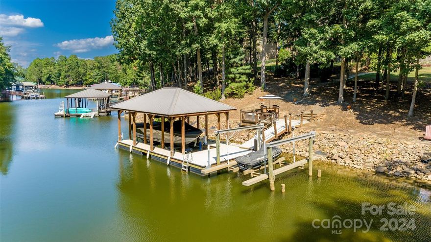 Exquisite waterfront home on a 1.14-acre cul-de-sac lot offering the best in quality craftsmanship & detail. Enter through custom stained-glass doors to an inviting, elegant yet comfortable home. The main floor great room features a stunning barrel ceiling, built-ins, & a gas F/P and adjoins the open dining & kitchen w/ island, SS appliances, granite counters, & built-in desk. Just off the great room is an expansive screen porch with kitchen/grilling area. Primary suite on main with lavish en-suite, walk-in closet and its own private screen porch overlooking secluded backyard. Secondary bedroom w/ en-suite on this level as well. Upstairs, find an amazing media room & half bath. The lower level offers a large great room w/ gas F/P, built-ins, and rec/billiard area. Two bedrooms with en-suite baths, an additional room w/ en-suite bath & closet, and an exercise room complete this level. Semi-finished heated/cooled basement storage. Pier with deck, covered dock, 2 lifts & 2 jet ski lifts.