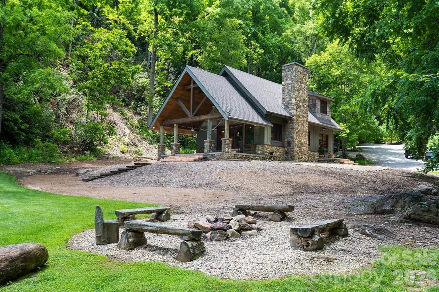 Indigo Nature Retreat. An incredible setting, main house, that is the lodge and nine guest cabins. On 4.25 pristine acres with more than 1,000 acres of undisturbed Pisgah National Forest at its doorstep, Indigo Nature Retreat offers an extraordinary opportunity to live in harmony with nature. This rare mountain sanctuary is immersed in beauty, surrounded by dense foliage, winding trails and soothing sounds of rolling currents, while offering thoughtfully designed spaces for gathering, reflection and retreat. The heart of the property is the main lodge, a 1,000-plus-square-foot haven that embodies rustic elegance. With a private loft and main sleeping quarters, it provides comfort and seclusion while honoring its natural setting. The open living area, anchored by a handsome stone fireplace, invites conversation and connection, while a spacious porch extends into the forest canopy, offering a backdrop for sunrise meditations, evening storytelling or quiet contemplation. Warm natural finishes throughout ensure the lodge feels welcoming and enduring. A two-story, 600-plus-square-foot community barn serves as the property’s vibrant center. On the main level, two full baths, a dining area and a fully equipped kitchen, complete with stove, microwave, dishwasher, refrigerator, cookware and utensils, create a communal space for shared meals and celebration. Upstairs, an open studio awaits, ideal for yoga, meditation or creative expression, making the barn a hub of connection and inspiration. Scattered throughout the retreat are accommodations that balance privacy with immersion in nature. Five primitive tiny cabins, neatly tucked into the forest, invite simple, restorative living, while four larger creekside cabins, each with a full kitchen and bath, provide greater comfort without sacrificing serenity. Altogether, the property accommodates up to 24 guests, offering flexibility for family gatherings, wellness retreats or intimate hospitality experiences. Operating as a retreat center, Indigo Nature Retreat is far more than real estate, it is a soulful offering, a place where nature leads and peace follows. Whether envisioned as a private legacy estate, a continuation of its role as a sanctuary for wellness and creativity, or an opportunity to reimagine a personal or professional connection to the land, this property embodies possibility. Just beyond the doorstep lies mile upon mile of untouched wilderness, yet the retreat remains accessible, a secluded escape within reach of Asheville’s vibrant cultural life. Indigo Nature Retreat stands as a rare convergence of beauty, tranquility and purpose, a place where mountain living is not only elevated but deeply meaningful.