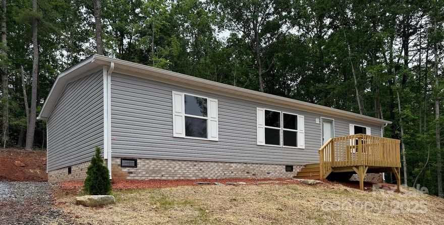 NEW HOME, AFFORDABLE & MOVE-IN READY!!!  Doublewide Manufactured home in Burkeshire Estates on approximately 0.5 acres. Featuring three bedrooms, two baths, living area that opens to the kitchen and dining nook. The kitchen has a refrigerator, range, dishwasher, and island offering extra cabinet and counter space. Sliding glass doors open from the dining area to an outside private deck. Great for entertaining or just relaxing in this beautiful country setting. Split bedroom plan offers privacy for the primary bedroom. All bedrooms have large walk-in closets. The spacious laundry room is found off the kitchen with washer and dryer hookup.