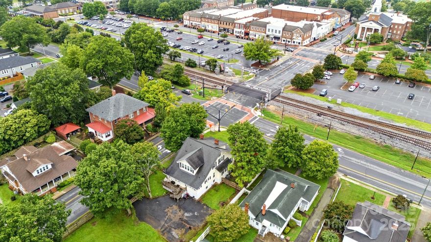 Welcome to this beautifully preserved historical style gem nestled in the heart of Kannapolis. This spacious 6 BDR 2 1/2 bath residence offers a perfect blend of classic charm. Step inside to discover the inviting atmosphere, featuring unique architectural details that reflect its storied past. The home boasts updates throughout, and original hard wood floors , enhancing its character. The fully fenced backyard is a private oasis, perfect for outdoor gatherings, gardening, with  ample space, this backyard is a true sanctuary. Located across the street to downtown Kannapolis, you'll have easy access to local shops, restaurants, the Cannon Ballers baseball field, making it a prime location for entertainment and leisure. Notably, this property was once zoned for commercial use, offering potential for rezoning that could open up exciting opportunities for businesses or mixed-use development. Don't miss the opportunity to own this remarkable home that combines history, space, and location.