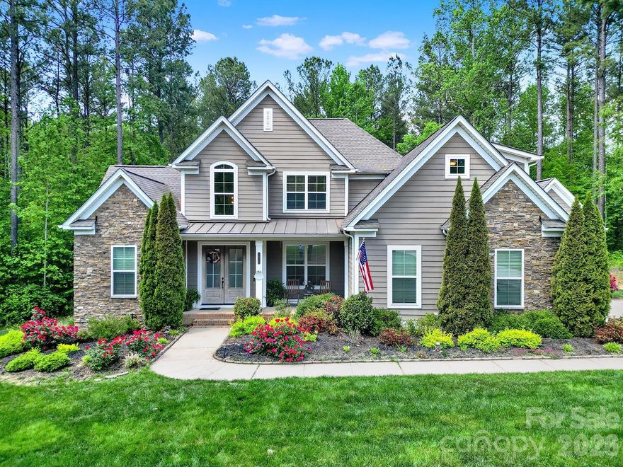 Experience refined luxury in Henry’s Glen with this custom-designed estate set on over 2 acres of serene, wooded surroundings. Showcasing exceptional craftsmanship, the home features soaring 12–14’ coffered ceilings and rich hardwood flooring throughout, creating a warm yet sophisticated atmosphere. The chef’s kitchen is a true centerpiece, complete with an oversized island, gas cooktop, and exquisite cabinetry, all seamlessly flowing into light-filled living spaces enhanced by expansive windows. A spacious walk-in pantry and generously sized laundry room with abundant cabinetry add everyday convenience. A dedicated office provides the perfect work-from-home space, while upstairs you’ll find two bonus rooms offering incredible flexibility for a media room, playroom, or fitness space. The luxurious primary suite is a private retreat, featuring dual vanities, a large soaking tub, a separate tiled shower, and oversized walk-in closet. Each of the four bedrooms includes its own en-suite bath, with the fourth bedroom also offering versatility. Step outside to your own backyard oasis, complete with a screened-in porch, custom flagstone patio, fire pit, and lounge area, ideal for relaxing or entertaining year-round. A large three-car garage completes the home’s impressive features. Ideally located just a short drive from Charlotte Douglas International Airport, premier shopping and dining, and within the award-winning Clover School District, this exceptional property offers the perfect balance of luxury, privacy, and convenience.
