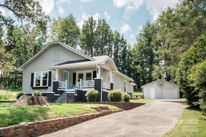 This charming bungalow in historic downtown Valdese is back on the market! Sunlight fills the open living and dining area, highlighting the beautiful hardwood floors, high ceilings, and cozy fireplace. Two spacious bedrooms and a kitchen with to-the-ceiling cabinetry offer both style and function. The laundry/mudroom is a handy drop zone and offers potential for a second bath. Set back on a gentle hill with easy access to downtown, enjoy peaceful mornings on the covered porch swing overlooking a large side yard—perfect for gardening, pets, or play. Detached 1-car garage with updated door. Sellers are offering a $5,000 credit for updates of your choice—now’s the perfect time to make it yours!
