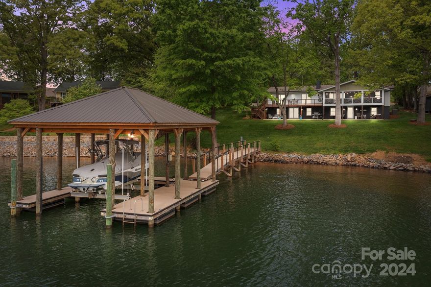 Welcome to your lakeside paradise! This completely renovated home has been exquisitely designed and thoughtfully curated with the perfect balance of modern and rustic charm. Set on a .69 acre lot with stunning Lake Norman views, privacy and mature trees, this home is the ideal getaway to enjoy the lake life. Step inside, and you are greeted by an interior that is both sophisticated and inviting. The open-concept design maximizes space and natural light while showcasing the lake views from almost every room. Vaulted ceilings, elegant finishes, and designer fixtures elevate the aesthetic appeal, while warm hardwood floors, custom shiplap, modern cable staircase add a sense of warmth and nautical character. A complete 2019/2020 renovation (all permitted) including new pier, dock, boat lift, windows, doors, siding, roof (2024), paver patio (2024), electrical panel, deck with cable railing, screened porch, septic tank and well. No detail left unnoticed in this lakeside masterpiece!