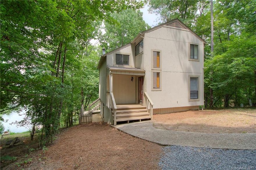 Live on the lake for under $300,000! Charming 3-bedroom waterfront cottage on a quiet cove. Two-story entry w/ one bedroom on the first floor great for home office or guest room. Kitchen opens to a two-story great room and wood-burning stove.  First floor laundry room and 1/2 bathroom.  Paved & gravel driveways provide ample parking. Outside features two levels of decks great for entertaining. Located in amenity-rich Tega Cay with Fort Mill schools.   Convenient to shopping, dining, and I-77.