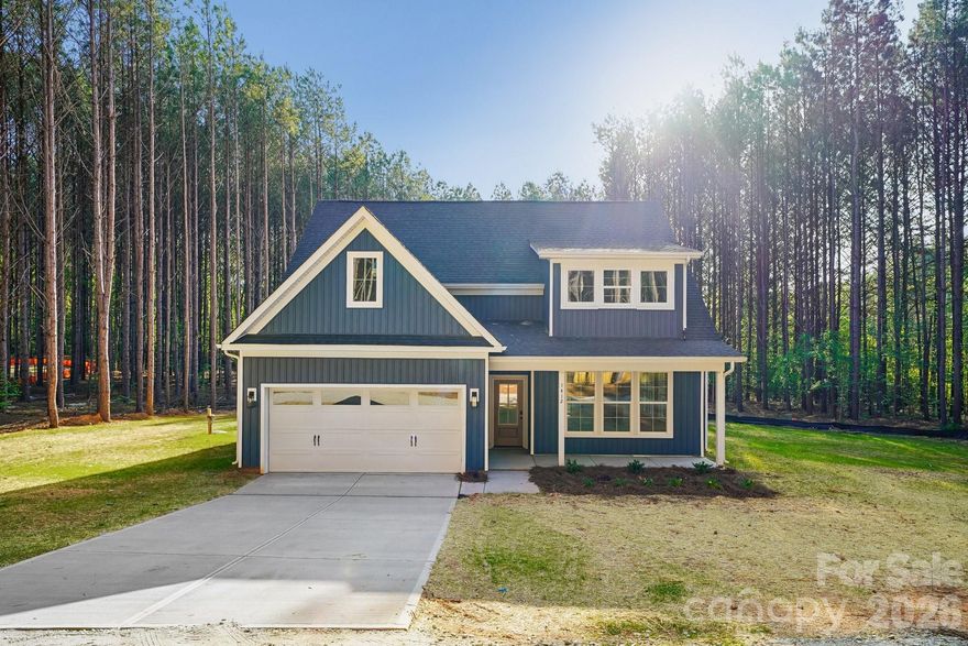 Welcome to this thoughtfully designed new construction home nestled on 1.58 private, wooded acres in York, SC. Blending transitional style with custom-quality finishes, this home offers an efficient and inviting layout perfect for modern living. A long driveway leads you to a spacious front porch, setting the tone for the comfort and charm found throughout.

The main level features an open-concept design with 9-foot ceilings that enhance the space, filled with natural light and complemented by recessed lighting throughout. Durable rigid core LVP flooring flows seamlessly through the main living areas. The living room is anchored by a cozy fireplace, while the kitchen impresses with a large island, shaker-style cabinetry, quartz countertops, and brand-new stainless steel appliances—including a refrigerator. Sliding doors open to a covered back porch complete with a ceiling fan, overlooking a serene, tree-lined backyard.

Convenience meets comfort in the first-floor owner’s suite, featuring a walk-in closet and a well-appointed bath with dual vanities and a tile shower surround. A laundry room with a utility sink is also located on the main level for added ease.

Upstairs, you’ll find three spacious bedrooms, a full bath, and a versatile loft area—perfect for a home office, playroom, or additional living space.

This home offers the perfect balance of privacy, style, and functionality—an ideal retreat just waiting for you to make it your own.