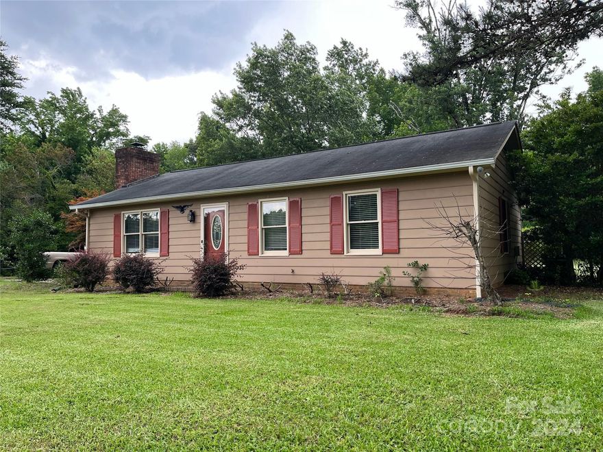 Quiet living yet just minutes to Rock Hill shopping. Freshly painted and ready to show. Cute 2 bed, 2 bath ranch on almost 2 acres beautiful large back yard! Good-sized primary bedroom with a very large closet. Family room has new luxury vinyl plank floor and a raised brick fireplace. Both bathrooms and kitchen have ceramic tile. Gas-log fireplace could convert back to wood-burning. Oversized 620 sqft deck with access from kitchen or primary bedroom. Large shed connects to pole barn which could become a carport. Entrance for a second driveway already installed at street. No HOA dues.