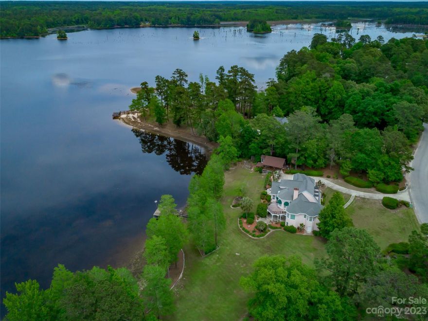 Magnificent waterfront home located in Southgate exudes sophistication & elegance. This custom 5 bedroom home offers a studio and an in-law suite! The living room, adorned with a dome ceiling & gas fireplace, is the perfect spot for relaxing. The kitchen boasts beautiful cabinetry & luxurious granite counters. There is a large breakfast area with breathtaking water views. A large deck is just off of the breakfast area is the perfect place to watch those Carolina sunsets. Off of the kitchen is a butler's pantry & wet bar that conveniently connects to the dining room. The primary suite is on the main floor & features a large bathroom with a jetted tub, water closet, shower & walk-in closet. Upstairs you will find 3 additional bedrooms. Downstairs is an entertainer's dream featuring a gas fireplace, bar area, sauna & French doors leading out to a covered patio area. You'll love the 427sf studio with exposed wood beams, new roof & antique sink! Call for a private tour.