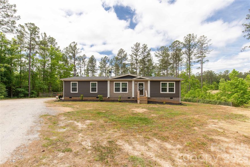 Tucked away in a private country setting on 3.13 acres, 412 Mullinax Cir is the kind of place that makes you want to slow down, sit by the fire, and maybe finally buy that tractor you’ve been talking about. Built in 2021, this 1,584 sq ft home is loaded with thoughtful upgrades and charm throughout. Inside, you’ll find crown moulding, a large open floor plan, and a beautiful stone wood-burning fireplace that anchors the living room. The kitchen is a showstopper with a HUGE island, tons of cabinet space, and a walk-in pantry big enough to make a bulk grocery run feel justified. The flex space offers room for a dining area, office, or whatever fits your life best. The primary suite features a freestanding soaker tub, tile shower, and a peaceful retreat feel. Outside, enjoy a fenced backyard, plenty of room to spread out, and a 20x18 workshop ready for hobbies, storage, or projects. Country living, modern finishes, and just the right amount of “wow.”