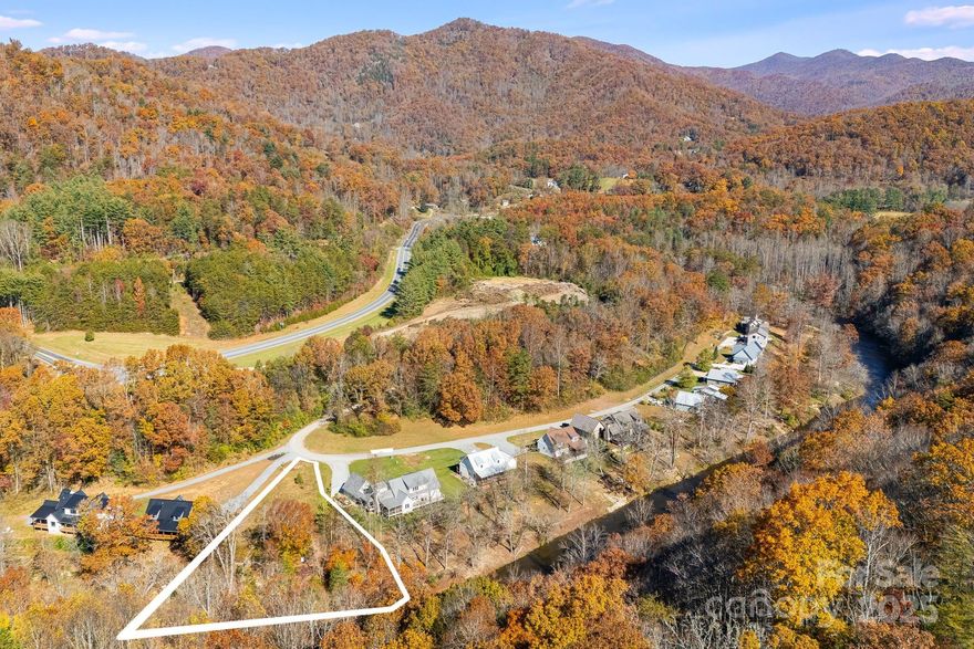 Discover the perfect blend of mountain beauty and build-potential on this rare flat riverfront lot. Set along a peaceful stretch of the Tuckasegee River, this property offers direct water access, year-round views, and the ideal terrain for your dream home. The land is open, and exceptionally usable—something hard to find in the mountains—giving you freedom for outdoor living spaces, gardens, or a private riverside fire pit. Mature trees along the riverbank provide natural shade and privacy. Enjoy fishing, kayaking, and tubing right from your backyard, with nearby access to the charming mountain town of Sylva and Western Carolina University's campus. *The buildable portion of the lot is outside the Special Flood Hazard Area per FEMA's LOMR-F.*
