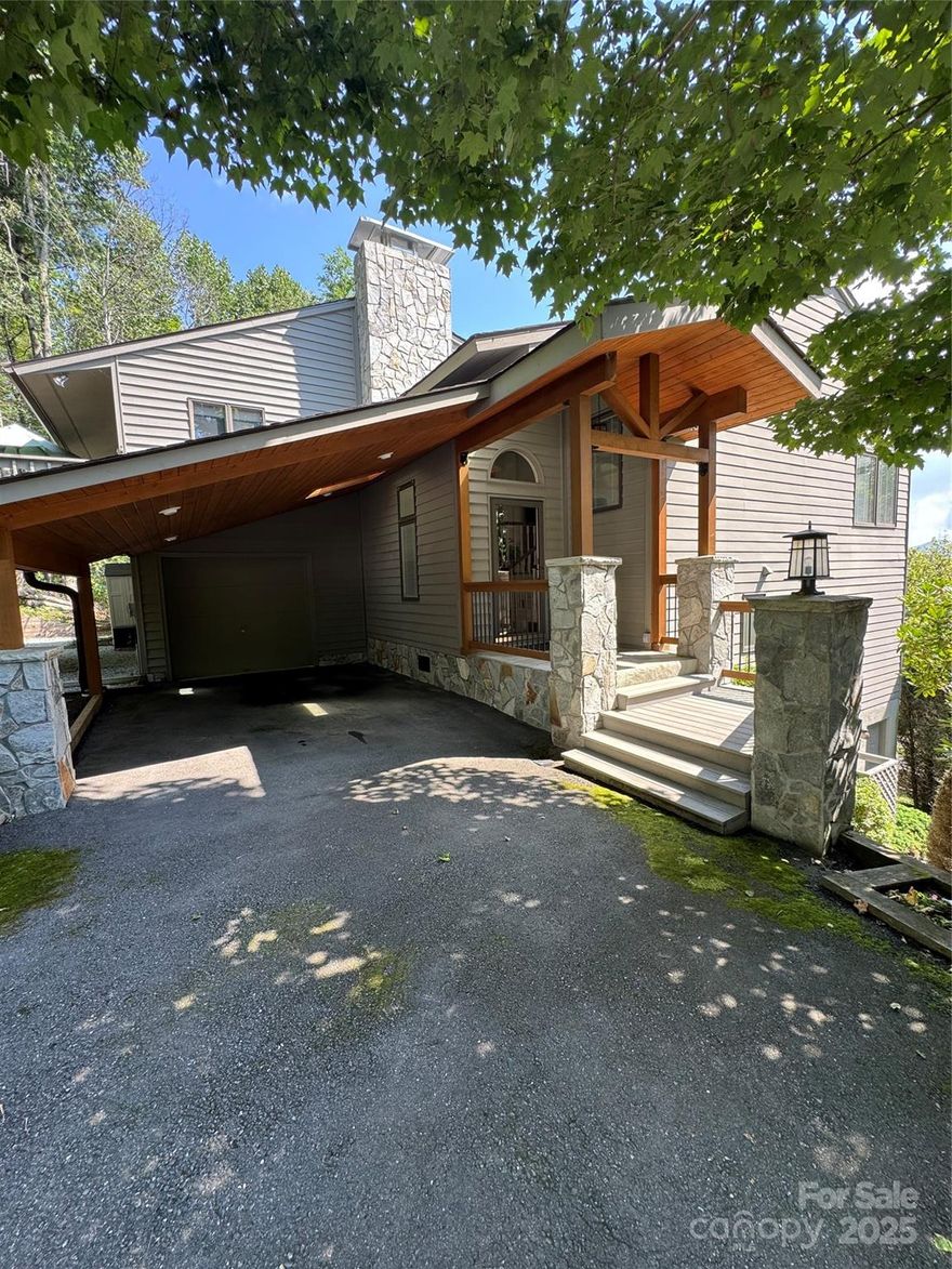 Stepping through the front door you notice a spacious living room with coffered ceilings, filled with natural light and breathtaking views. Dining room and kitchen feature vaulted ceilings, granite countertops, high-end stainless-steel appliances, custom cabinets and much more!. Notice the large outdoor deck, floored with durable Bangkirai wood. Overlooking the dining area, you’ll find a large office area with its own deck. One of the guest bedrooms and baths are on this level as well. With just a few steps find a en suite primary bedroom. All with a mix of engineered wood, vinyl, and ceramic tile flooring. The lower level boasts a spacious en suite primary bedroom complete with an oversized walk-in closet and a luxurious bath featuring a tiled shower, double sinks, and distinctive mirrors. This level also includes a living area with a den, dining nook, along with a full bath and laundry. Additional highlights include a garage with workshop space, a carport, and a generous driveway.