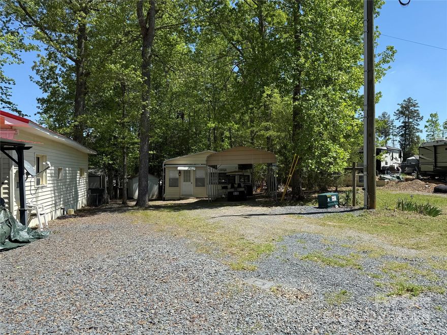 Oversized lot with lots of common area out back. The 1984 Leisure Craft with addition has been updated and is ready for you to come enjoy the summer. or live here full time. 2 bedroom, 1 bath. All electric unit, HVAC, 12 x 18 Metal Carport for boat or car, large shower/tub, real potty, desk area and many more.  Covered deck out back to enjoy the quiet of the common space that has been added to this lot. 8x6 storage building. All items in camper are to remain. Items in addition are not included. All clients must be with realtors to gain entry to the park.