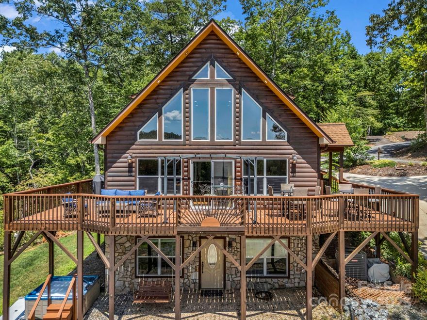 Located behind the gates at Rumbling Bald, this log-sided cabin overlooks the 12th green & mountain views which cab be enjoy from the expansive decks or the hot tub. The living room features a soaring tongue&groove ceiling, hardwood floors, & a stone-accented gas fireplace. The kitchen offers granite countertops, hickory cabinetry, stainless steel appliances & large kitchen island. The main level features a separate laundry room, primary bedroom w/ walk-in closet, massive bathroom w/ dual vanities, tile shower & jetted tub. With three primary suites-one on each level, a spacious loft, den w/ gaming area, this layout truly supports flexible living. The basement includes a second laundry and private entry—ideal for lots of guests or potential rental use. Additional features include a tankless water heater, generator, & storage shed. Community amenities include two golf courses, private beach, lake access, restaurants, salon & spa, fitness center, tennis courts & more! Offered furnished!