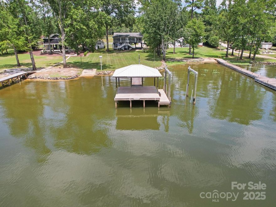 Welcome home to Lake Wateree! This well loved lake home has hardwood floors, updated kitchen with tile flooring and solid surface countertops. Great room with shared dining area with spectacular views! 583 SF (not included in SF) Studio apartment on lower level has laminate flooring, granite countertops, cooking area and bathroom. Owners suite features private bathroom and walk-in closet. Enjoy relaxing views on large screened porch perfect for entertaining. Boat ramp, covered dock with boat lift. Detached workshop with electric. Home has plenty of storage for your water toys. This location is just a golf cart ride away to nearby marina, amenities and restaurants!