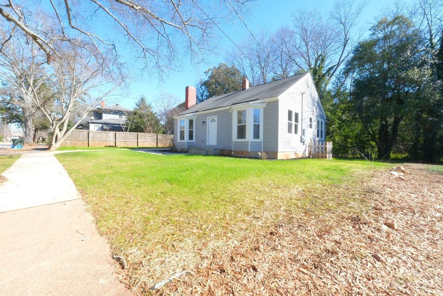 This quaint and cozy residence exudes character and warmth. Originally built in 1950, this small, old house has undergone a complete transformation and now showcases a perfect blend of historic charm and modern convenience.
The open floor plan creates a seamless flow between the living room, dining area, and kitchen, providing a welcoming space for both everyday living and entertaining guests. The newly resurfaced hardwood floors add a touch of elegance, while large bay windows flood the rooms with natural light, creating a bright and inviting atmosphere.
As you step outside, the charming exterior complements the surrounding landscape, and the freshly landscaped yard provides a peaceful retreat for relaxation. Conveniently located near downtown Rock Hill, this home offers the perfect combination of tranquility and accessibility.