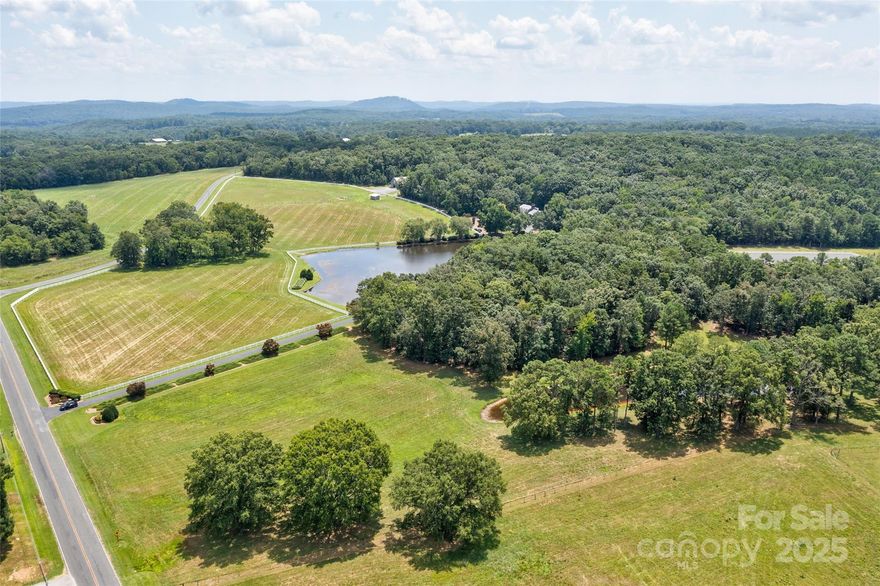 Over 300 acres of permanently protected NC wilderness & pasture land form this rare breathtaking estate, donated to the Three Rivers Land Trust to preserve biodiversity & heritage. The land includes over 300 acres of hardwood & pine forest, 13 acres of fenced pasture, 30 acres of hay fields & four natural stocked ponds, all connected by a private trail system ideal for hiking, riding & wildlife observation. The residence is a full-brick, custom-built home, thoughtfully tucked well away from the road & private. Equestrian amenities include a 3-to-5-stall barn & a 100' x 250' arena, supported by several outbuildings & workshop spaces. A second private building envelope (2nd home needs extensive renovations or replacement) provides the opportunity for a guesthouse, retreat or multigenerational expansion. Located near Badin town center, a regional airport, Morrow Mountain State Park & the waters of Badin Lake, this estate offers ecological purpose, privacy & a lasting legacy of stewardship