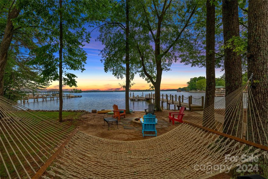 Nestled on the serene shores of Lake Norman, this exceptional waterfront home offers breathtaking views. Looking for long range views with a private beach on a level lot, this is it! Slice of paradise awaits you to start enjoying your lake life. Direct access to the water for boating, kayaking, or simply relaxing on the natural beach under the trees by the water. This charming ranch home features vaulted family room & sunroom that creates a spacious & airy feel. The open living area is perfect for all your friends & family to gather while enjoying the views from indoors. Kitchen offers bright cabinets, granite tops & stainless appliances. The expansive primary suite hosts additional sitting or office space along with an updated dual sink bathroom. Updated guest bath with timeliness neutral finishes, gold fixtures & tile walk in shower. Private second living quarters with privacy. Additional workshop and storage is a bonus for work or storage needs. Home will be sold fully furnished.