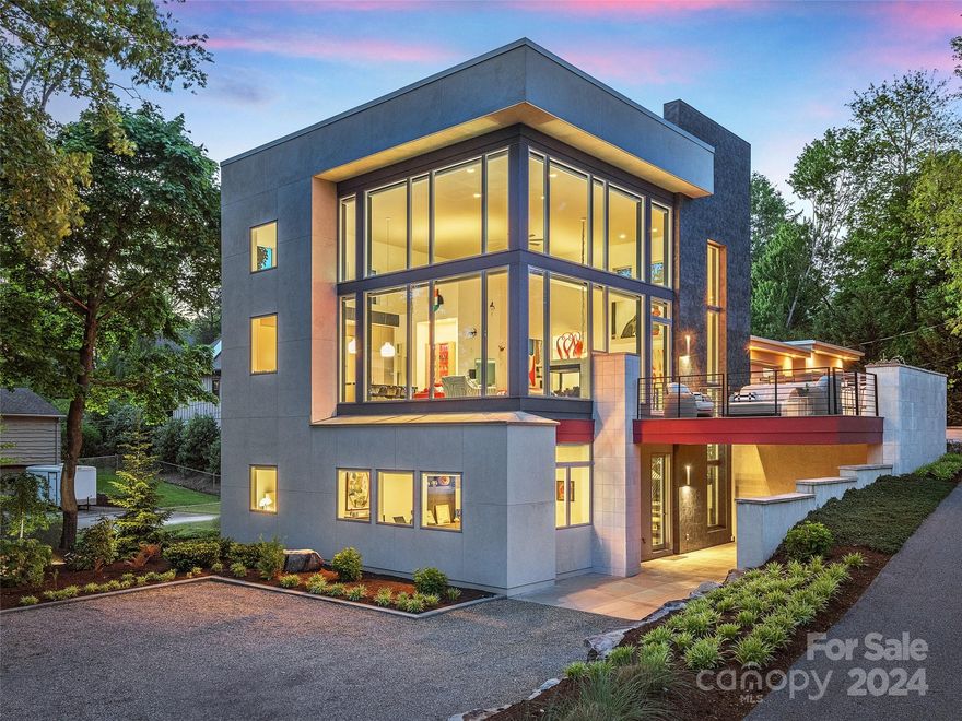 The ‘Glass House’, aptly named for its striking architectural design, stands as a contemporary masterpiece on the shores of Beaver Lake in N Asheville. This impeccably designed residence seamlessly blends sleek sophistication with a love for nature, creating the ideal setting for lavish gatherings, showcasing your art collection, or simply unwinding and relaxing before the sweeping lake and sky views. The main level offers unparalleled convenience and elegance, boasting a breathtaking great room with soaring ceilings and windows, gourmet kitchen, and a primary sanctuary with convenient laundry all bathed in natural light. The extensive collection of artisanal lighting elevates the everyday into a sensory experience. Privacy meets versatility on the terrace level - a haven for guests with their own family room, easy transitional office or bedroom suites or dedicated hobby space all with an easy access carport. This remarkable home fulfills your desire for luxurious mountain living.