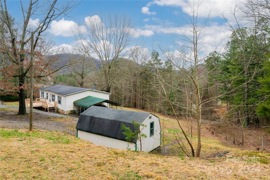 Large 1.03 acre lot with mountain views located in the picturesque Reems Creek Valley across from the Gov. Zebulon B. Vance Historical Site. Vaulted ceilings, open floor plan with dining area and a wood burning fireplace.  Split bedroom floor plan, primary suite with walk-in closet, en-suite bathroom, soaker tub and walk-in shower. Extensive green space with endless possibilities perfect for gardening, pets and play. Carport and plenty of extra off street parking. Large storage shed conveys. Reems Creek Cemetery Trail Head a stones throw away. Minutes to the Blue Ridge Parkway, downtown Weaverville and 20 minutes to downtown Asheville.