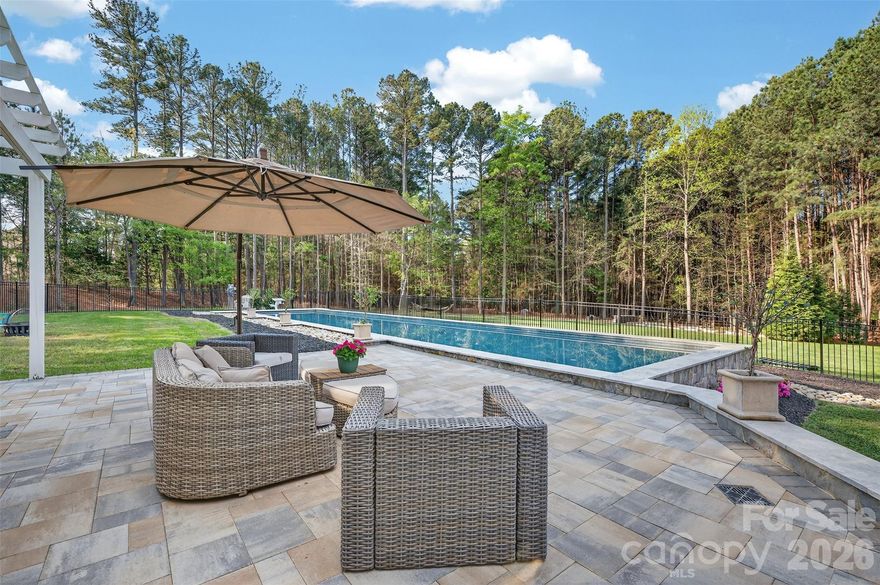 There are homes that check boxes… and then there are homes designed for how you actually want to live.

Set on a beautifully private cul-de-sac lot in The Point, this exceptional property delivers a rare combination of performance, wellness, and everyday luxury. At the center of the outdoor experience is a 75’ heated saltwater lap pool, complemented by expansive travertine decking and multiple spaces designed for wellness, entertaining or quiet retreat. Surrounded by mature landscaping, the setting offers remarkable privacy with ample room to relax, play, garden, or simply enjoy the calm.

The home itself blends timeless Southern charm with seamless indoor-outdoor flow. A wraparound porch with classic Carolina blue ceilings creates a warm and inviting entry. Inside, the main level showcases hardwoods, detailed millwork, wainscoting, plantation shutters, and a bright, open layout designed for flexibility. A front room with ¾-height wainscoting offers versatility as a study, sitting room, or dining space. The great room with gas fireplace connects effortlessly to the chef’s kitchen, featuring a Sub-Zero refrigerator, farmhouse sink, warming drawer, and oversized island. A sunroom filled with natural light overlooks the backyard, reinforcing the connection between indoor comfort and outdoor living. The main-level primary suite offers a spa-like bath with clawfoot tub, walk-in shower, dual vanities, and a spacious closet, along with the convenience of main-level laundry and a thoughtfully designed drop zone.

Upstairs, three generously sized bedrooms with walk-in closets are complemented by two full baths and a versatile bonus room with pocket office, while a large walk-in attic provides exceptional storage.

A defining feature of the property is the detached accessory dwelling unit, connected by a breezeway and thoughtfully designed to extend the home’s functionality. Currently used as a private fitness and pool space, it features vaulted ceilings, a full bath with dual-head shower, laundry hookups, and independent climate control. Whether envisioned as a wellness studio, guest retreat, home office, or flexible living space, it offers a level of versatility rarely found.

The outdoor living continues with a pergola-covered patio and multiple seating areas surrounding the pool, creating an ideal setting for gathering and entertaining. Framed by a wooded backdrop, the expansive lawn enhances both privacy and usability, offering space to play or unwind.

Luxury, privacy, and a lifestyle centered around intentional living come together in this one-of-a-kind offering.

Experience The Point, where amenities include a championship golf course, clubhouse, dining, fitness center, tennis and pickleball courts, pools, walking trails, and a vibrant calendar of social events. A minimum membership to Trump National Golf Club is required. Additionally, home comes with a dedicated boat slip lease opportunity.

Welcome Home.