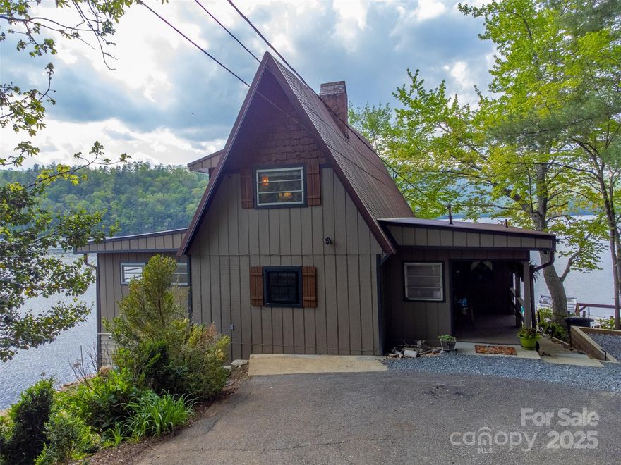 This lakefront home has the perfect location sitting on a point with stunningly beautiful panoramic views. Looking across the pristine clear water, you see the undeveloped land of the Nantahala National Forest with tons of wildlife including a bald eagle’s nest. This 3-bedroom home (with bonus room being used as 4th BR) features 2 full baths on the main level and a private upstairs loft bedroom with its own half bath. The updated kitchen opens to a spacious living area, perfect for gathering with family and friends. Step out onto the large deck or relax in the screened-in porch—both offering breathtaking views of the lake and the mountains beyond. A private floating dock provides direct lake access with a boat slip and 2 jet ski ports. The basement includes 3 separate bays ideal for storage, a workshop, or water toys. Ample parking for 5+ vehicles with a level entry into the front door. This home is a fabulous family getaway, or can be a great vacation rental.
