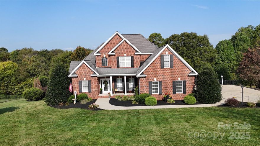 Elegant yet comfortably livable, this full-brick 3-bed, 3.5-bath home offers more than 3,000 sq ft of finished living space plus a large workshop area and an oversized garage—both with plenty of storage. From the moment you arrive, the manicured, well-landscaped yard—complete with outdoor lighting, speaker system, and security system—sets the stage for relaxed, resort-style living. Inside, hardwood and tile floors flow through three separate family rooms—one on each level—giving everyone a place to gather or enjoy quiet time.

Upon entry, soaring cathedral ceilings lift your spirits. A formal dining room and a comfortable living room—featuring custom bookcases with rippled-glass fronts, detailed moldings, and a gas fireplace—allow you to feel at home without compromise. Don’t overlook the half bath showcasing a 100-year-old antique vanity.

The kitchen is designed to impress with maple cabinetry, granite countertops, indirect lighting, a built-in wine rack, and clever appliance cabinets with hydraulic lifts and pull-out slides. From the pantry to the glass-front display cabinets, this kitchen gets the job done—and looks fabulous while doing it!

Speaking of beautiful, functional spaces, let’s talk laundry. It won’t do the chores for you, but you won’t mind spending time in this well-appointed room with a large sink, custom maple cabinetry, and stylish, practical organization.

When it’s time to unwind, step out into the completely enclosed screened porch—perfect morning, noon, or night. From coffee to cocktails, this insect-free outdoor living space lets you completely relax to the soothing sounds of your fountains. The primary suite also opens to a pergola for quiet moments; or, if you prefer a soak, enjoy the 92-gallon jetted tub with its own dedicated water heater.

On the lower level you’ll find abundant storage, a storm-safety room, and flexible space ideal for a home business. Don’t miss the second family room with a kitchenette and full bath—making a full day of poolside fun effortless.

Outside, just relax and enjoy the quiet. Designed for year-round enjoyment, a sparkling pool with waterfall and passive heating anchors the fenced yard, while the huge covered lanai offers shade and privacy. The fire pit is the perfect way to finish a cool Carolina evening.

Beautifully maintained and virtually maintenance-free outside, this home pairs elegant finishes with everyday practicality—just fifteen minutes from both Lincolnton and Hickory in a peaceful, highly desirable neighborhood.