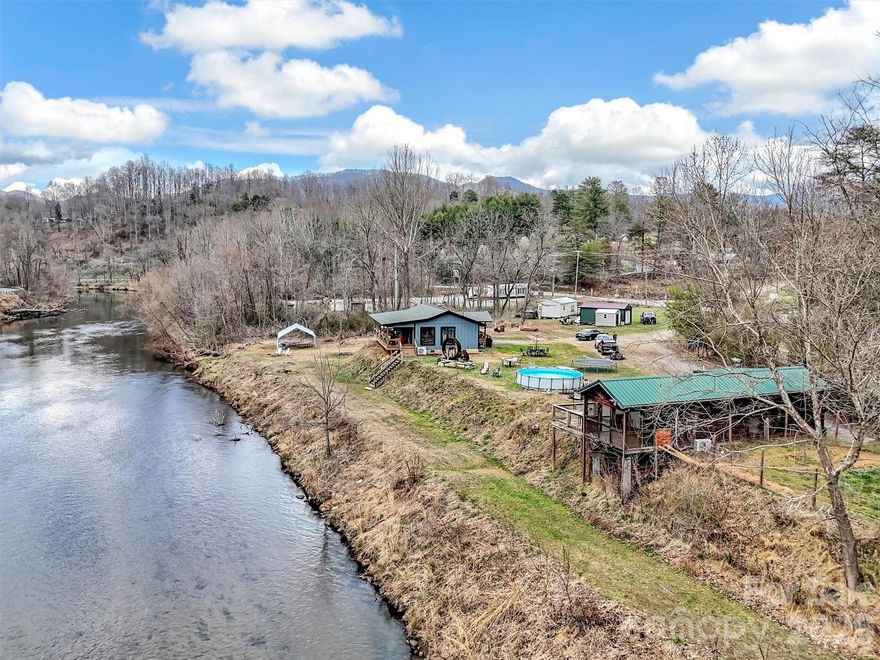 Exceptional river frontage property offering in the mountains of western North Carolina!  This level 1.67 acre parcel with a cabin overlooking the river features 400 feet of frontage on the beautiful Tuckaseegee River, popularly referred to as "The Tuck".   Featured as a primary river for rainbow trout dry fly fishing, the Tuck is a year round outdoor recreation destination.  

Ideally positioned in Dillsboro area on North River Road (NCSR 1359) and just off US23/441, the primary north/south roading leading from Atlanta to Cherokee, the Great Smoky Mountains National Park and the Asheville area.  Dillsboro is the intersection of 23/441 and US 74, the Great Smoky Mountains Expressway, and thousands of cars pass through the area every day.  The property's location  combines easy accessibility with privacy in a scenic setting along the river but features water and sewer served by the Tuckaseigee Water and Sewer with four (4) taps in place.

The parcel's flat topography, expansive river frontage and generous road frontage creates a compelling canvas for a boutique lodge, riverfront restaurant or brewery, curated short-term rental concept or private estate.  The choices are unlimited.  While the property adjoins both of the towns of Dillsboro and Sylva, there is no zoning, allowing a broad range of residential, hospitality or commercial uses.  

Present uses of the property include a park model rental which has produced a substantial income in a modified short term rental (3 months and longer).  The owners have a two bedroom, two bath cabin overlooking the river and features a covered porch with hot tub overlooking the river.  The river frontage area has  been terraced down to the river and is included in the flood plain but the great majority of the property is high enough not to be in the food plain.  Hurricane Helene's heavy rains brought the water level up and into the terraced areas but did not encroach onto the level parts of the parcel.

Opportunies offering this combination of infrastructure, road and river frontage, location and flexibility along the Tuckaseegee River are rare and this presents both a lifestyle asset and a compelling long-term investment.