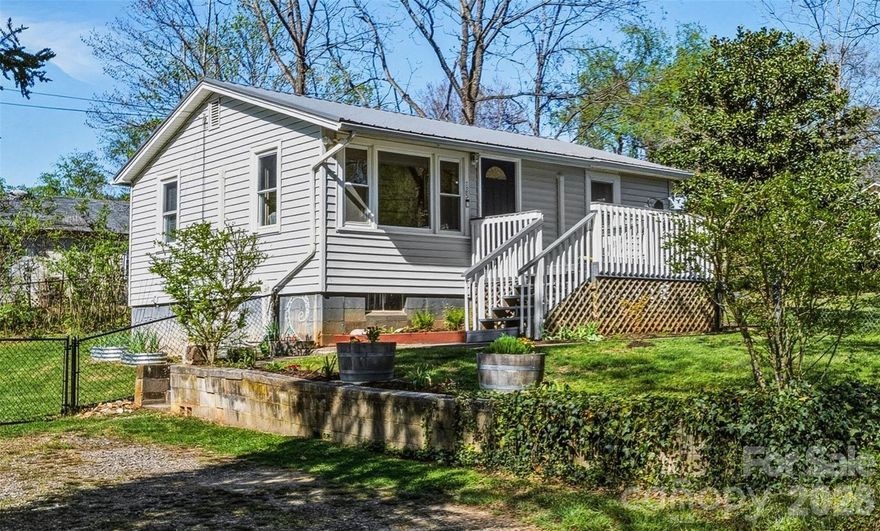 Lovely cottage-style home in a quiet Candler neighborhood on a spacious, level 0.29-acre lot! You’ll immediately be attracted to the gorgeous curb appeal of this well cared for home and outdoor space. Enter the home to a spacious living room and a house that lives much larger than its footprint. The primary bedroom provides ample room for relaxation while the beautiful open kitchen provides a great space for cooking, entertaining, or morning coffee. Outdoor space? This property has plenty! With a large deck-style front porch, side patio, and primarily fenced level lawn, there are several spots to enjoy some relaxation in the sun, sounds of the morning birds chirping, or the expansive night sky. With several recent updates, you’ll find a turn-key escape from daily life– all within mere minutes of downtown Asheville and in close proximity to all the outdoor fun Western North Carolina has to offer.  Recent major updates include a new metal roof and flashing (2025), new dual-head mini split ductless heating and cooling system (2022), and new Samsung dishwasher (2023).  Many more cosmetic updates and upgrades as well!  Finally, don't miss the ample storage available in the basement area.  Plenty of room to store all your extras; outdoor, camping, and water equipment; and seasonal items.  Don’t miss this amazing home! At this price, a gem like 125 Lower Edgewood Road won’t be on the market long!