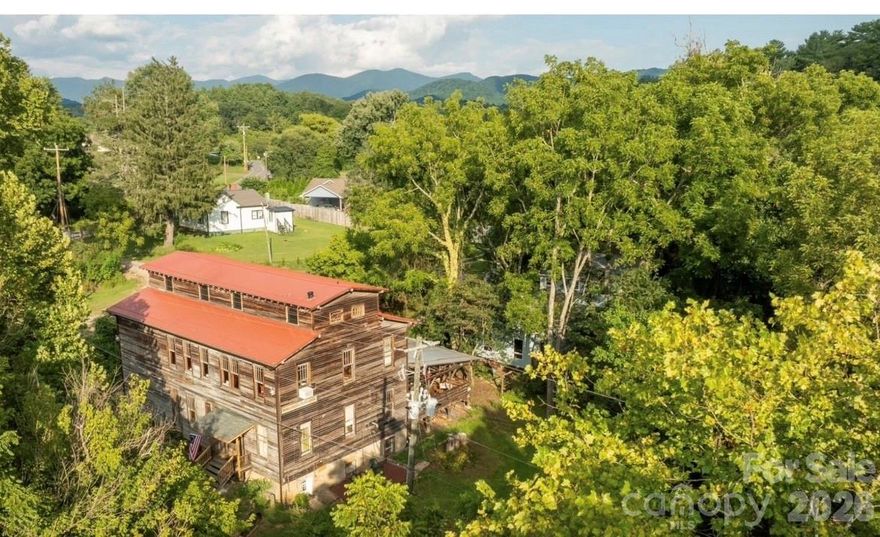 Historic Weaverville Milling Company.  Circa 1914 ...Ready for additional restoration. Would make Incredible Custom Home or Club with renovations! Rare Opportunity.....150+ year old Grist Mill / former 150 seat Restaurant includes 3 bedroom House and 1 bedroom Cottage, on 5.25 acres, fronts 1,000 ft. on Reems Creek waterway. Located in the County & only 10 min. to Downtown Asheville.  Ideal for Private Club, Event Space, Custom Home w needed updates or Restaurant.... The Mill is over 7,000 sq.ft. + 1,400 sq ft  covered patio. The Old Mill building is beautiful with strong local history. Old house (1940s) remodeled w 3 bed /2 bath approx, rear deck, large unfinished lower level daylight basement. Old Cottage remodeled w 1 bed and 1 bath , kitchenette approx. 600 SQ Ft with 300 sq ft rear deck.    Zoning allows short term rental and mixed use commercial.   1 Old Mill lane lot zoned EMP, 9 Old Mill lane zoned R-3. Not in Weaverville City limits. Property has City Water,  Sewer & Natural Gas.  Structures not impacted during Helene. Property has incredible private sanctuary along the waterway. Some photos enhanced with AI to show update potential and residential potential. .