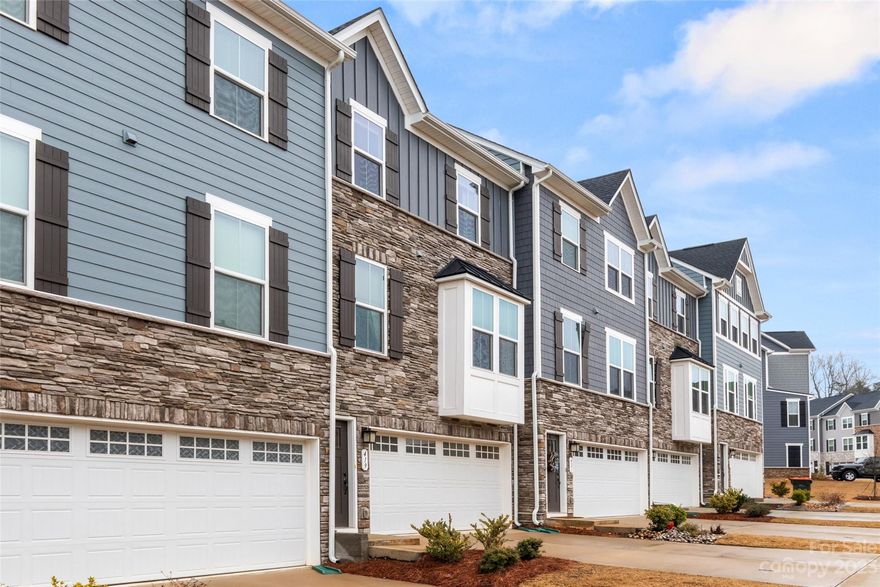 Be Prepared to be impressed with this Beautifully appointed townhome in Tega Cay that shows like a model home. Be sure to notice all the nice designer touches:  Marble backsplash in kitchen, accent walls, primary closet built ins.    Great location, award winning schools and with low HOA dues makes this home a great choice if you are looking for all that Tega Cay has to offer.  2 Car garage and flex space on main level - use this space the way it makes sense for your living:  home gym, office, play space or just extra living space.   Second floor is open living space with a beautiful kitchen with SS appliances, gas range and Large island, dining area and living area.  Lots of natural light in this space - open and airy. Deck located off of the kitchen.   Seller will be conveying the  Washer/Dryer and Refrigerator as an added bonus.  Primary and 2 secondary bedrooms located on the 3rd floor.