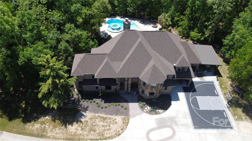 Tucked away on 10.31 private, wooded acres just minutes from the heart of Waxhaw, this stunning estate offers a rare blend of luxury, privacy, and natural beauty. A gated entrance and winding quarter-mile driveway create a true sense of arrival, leading to an impressive 8,276 square foot home thoughtfully positioned within a serene, nature-filled setting.
Built in 2007 and beautifully maintained, the home features 4 bedrooms per septic permit (with 5 total bedrooms), each with its own full bath, offering flexibility for guests, multi-generational living, or private office space. The main-level primary suite is a true retreat, complete with a spacious en-suite bath, dual vanities, and peaceful views of the surrounding landscape.
The main level is designed for both everyday living and entertaining, featuring a granite kitchen that opens seamlessly to the expansive great room, along with formal living and dining spaces. Architectural details and custom ornamentation throughout the home add a refined, upscale feel while maintaining warmth and livability.
Upstairs, generously sized secondary bedrooms, a large loft, and an oversized bonus room provide flexible space for work, play, or relaxation. The fully finished walkout basement is built for entertaining, featuring a media room, bar area, game room, recreation space, and full bath—flowing effortlessly to the outdoor living areas.
Outdoor living is exceptional and truly sets this property apart. A multi-level deck overlooks the natural landscape, while the expansive patio—crafted from massive, natural stone—creates a one-of-a-kind outdoor gathering space. The gunite inground pool has been recently enhanced with new variable frequency drive (VFD) systems for improved efficiency and long-term cost savings. A tranquil seasonal creek runs through the backyard, further enhancing the peaceful, private setting.
The property is well-equipped for both lifestyle and functionality, featuring multiple outbuildings ideal for ATVs, tractors, and equipment, along with a 3-car garage and additional covered parking for two more vehicles.
Additional highlights include two fireplaces, whole-house water filtration system, new roof (2025), HVAC system (2025), new gutters, and extensive interior and exterior repainting. Spectrum fiber internet availability makes working from home seamless, even in this private, tucked-away location.
Zoned for Waxhaw Elementary, Parkwood Middle, and Parkwood High School, with many area families also choosing nearby Union Academy charter school.
This is a rare opportunity to own a private estate offering acreage, luxury, and convenience—just minutes from Waxhaw, while still within easy reach of Ballantyne, South Charlotte, and everything the region has to offer.