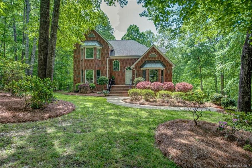 Stately home situated on a large wooded lot! House is currently used as a 4 bedroom. Basement level has full living apartment! Comes complete with kitchen, great room w/fireplace and french doors to patio. Custom cabinets throughout home. Master suite on main level with floor-to-ceiling windows overlooking beautiful yard. Great flow for entertaining! Kitchen is full of natural light and open to great room. Sunroom off kitchen. Multi-tiered deck for grilling. Backyard is a treasure!