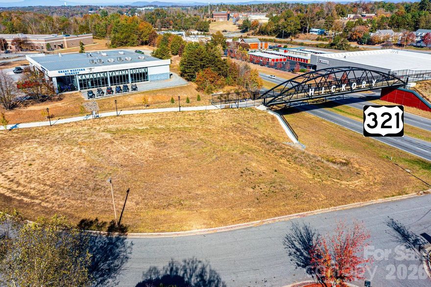 PRIME COMMERCIAL LOCATION along Hwy 321 and Hickory's Aviation Walk at the new pedestrian overpass crossing over Highway 321. This level, corner lot offers over 450 feet of road frontage and will feature a traffic light intersection after the expansion of Highway 321. Tax records indicate acreage as 0.59 acre, but part of that acreage may be affected by a permanent easement running along the City Walk, see associated MLS Docs. Exact buildable acreage is yet to be determined, seller is awaiting a completed professional survey. Currently daily traffic counts along Highway 321 exceed 35,000 vehicles per day. Pedestrian traffic across the Aviation Walk will soon open up, and the total passersby will go up even higher! The possibilities are endless!