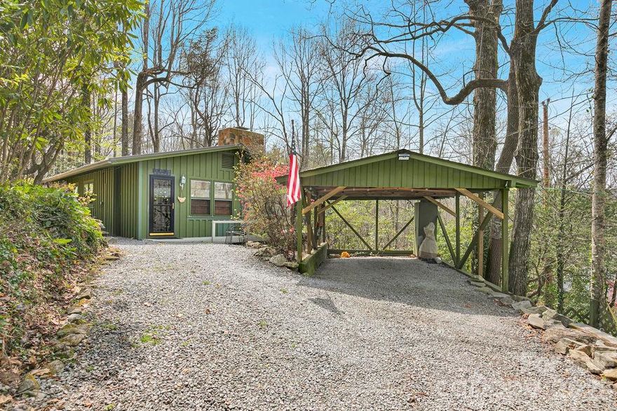 This inviting mountain cottage at 218 Hickory Lane offers a comfortable blend of charm and practicality, ideal for year-round living or a relaxing weekend getaway. Filled with natural light, the home features two bedrooms and two full baths, including a nicely updated bathroom with a classic clawfoot tub. The kitchen is efficient and functional, opening to a cozy dining nook and a comfortable living area with a new propane fireplace. Large windows throughout bring in plenty of light, creating a bright and welcoming feel even on cloudy days. A wraparound porch extends the living space outdoors, offering a great spot for grilling, dining, or simply enjoying the peaceful setting. There’s also a fire pit for cool evenings and gathering with friends and family. In the winter months, you’ll enjoy seasonal mountain views. Tucked away, this home offers a quiet, private feel while still being within close proximity of Pisgah, Dupont, and Brevard. A gated driveway and single carport add even more functionality. This is a great option for anyone looking to enjoy the simplicity and beauty of mountain living in Lake Toxaway, NC.