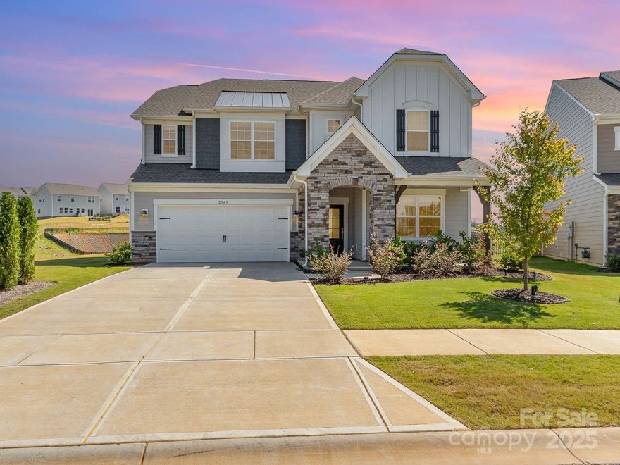 Nestled in the coveted Elizabeth Subdivision of Fort Mill, this 2024-built home exudes a sophisticated blend of modern elegance and meticulously curated design upgrades. Set on a premium lot with breathtaking horizon views, the home benefits from additional privacy with an HOA-maintained lot beside it. Inside, every detail has been thoughtfully enhanced, starting with the gourmet kitchen—equipped with a professional-grade gas cooktop, an oversized farm sink and a striking gold faucet. The formal dining room, graced by an upgraded chandelier and  built-ins for a wet bar, is perfect for hosting elegant dinners, while the expansive living room boasts intricate wall paneling, lighting, and a refined ambiance. A set of French doors leads to a tranquil home office, complete with an upgraded chandelier and wall lighting that adds warmth and sophistication. The home’s staircase, featuring sleek metal rod railings and luxurious LVP steps. Upstairs, the primary suite and four generously-sized bedrooms offer stunning views, with luxurious finishes that elevate each space. Additional highlights include an upgraded vanity in the guest half-bath, epoxy flooring and freshly painted walls in the garage, and a smart home system powered by Google. Blinds and custom window treatments throughout enhance the home’s polished aesthetic. The exterior boasts classic shutters, stone accents, and artful landscaping, with front garden lighting that beautifully illuminates the entry. Future residents will also enjoy the upcoming amenities in the Elizabeth Subdivision: pool and cabana, fitness center, park, playground, pickleball court, trail and bocce ball. With its unparalleled design and premium features, this home is truly a masterpiece—better than new in every sense.