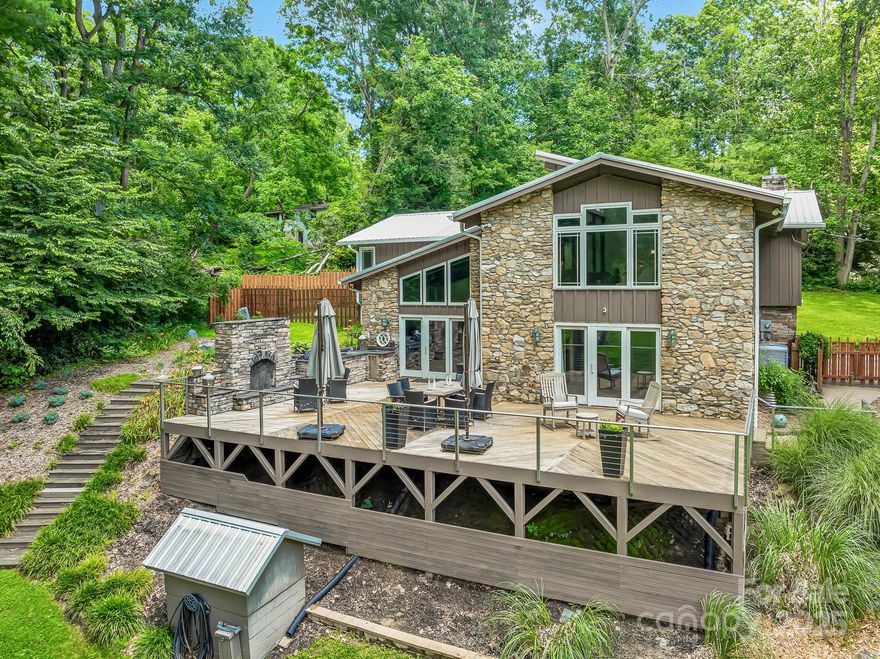 Welcome to this beautifully renovated home, where modern design meets effortless comfort. Bathed in natural light throughout, this spacious home features an open-concept layout and high-end finishes at every turn. Primary bedroom features a fireplace & sitting area while the walk-in closet is lined in cedar. Each generously sized bedroom is a private retreat, complete with its own ensuite bath—perfect for hosting guests in style. The heart of the home is a sleek, updated kitchen with premium appliances and designer touches, seamlessly flowing into expansive living and dining areas. Step outside to your own entertainer’s paradise, featuring a fully equipped outdoor kitchen with expansive deck & a rock fireplace overlooking a beautifully landscaped yard. The property also has a studio that can be used for art/yoga/crafts.  Below the studio is a workshop/garden shed. All of this on 3.5 acres close to downtown Hendersonville & Airport Rd. Home is just .50 from Advent Hospital.
