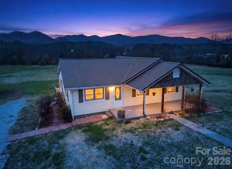 Just a short drive from the High Country, and nestled below the shadow of the HAPPY VALLEY Mountains, sits the Riverside Property you've been waiting for! Gorgeous Mountain Views, Over 3 Usable Flat Acres, and Frontage on the YADKIN RIVER! Level property with outbuilding, ideal for homesteading, or gardening, target shooting, or letting the kids run! The level yard leads to a picturesque riverside escape...where you can become one with nature. Sit at the picnic table and listen to the trickling waters, roast marshmallows in the fire pit, view the Eagle that calls this river Home, or string up that hammock and enjoy the valley breeze! Escape reality and "Go to the River" on your own property! Back at the house, you are met with beautiful flowering perennials, including gorgeous rose bushes on an arch trellis! A brick pathway leads to a charming covered front porch. This 3 Bedroom 2 Full Bath with Bonus Room, Bungalow has so many updates to mention! Metal Roof, Newer Heat Pump and Septic Tank...New Paint Inside and Beautiful Refinished Hardwood Floors! Semi Open Floor Plan leads to a Large Kitchen with tons of Storage and Cabinetry Space! 3 Bedrooms and a Bonus Room sit off of the Living Room and Kitchen. The Bonus Room could easily become a Luxury Walk In Closet, Attached Nursery, or Office to the Primary Suite! The Primary Suite has a large walk in shower with built in bench, perfect for winding down after a long day on the River! A Large Mud/Laundry Room is just off the kitchen and leads to the Full Length, Covered Back Deck. After a long day, retreat to this space and soak in the Mountain Views and Gorgeous Sunsets! The property owner is also willing to sell a neighboring 4 Bedroom 2 Bathroom Unfinished Home with 8+- acres, with the sale of this home. Hurry to claim your Riverside "Dirt" in Coveted Happy Valley Today!