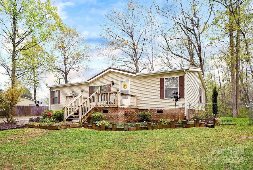 Looking for a beautiful, fenced in yard? Found it! This home sits up off the road for a semi remote feel. Paved and gravel driveway, several storage buildings, front and back decks, great landscaping. Primary bedroom and bathroom are on separate ends of the home from your second/third bedroom and additional bathroom. Come together in the large common areas. Living room is spacious and so is the kitchen. Open enough to communicate and entertain and yet well defined. Located not too far from popular destinations like Lazy 5 Ranch, The Quarry at Carrigan Farms and Lake Norman! Don't miss the opportunity to consider this great home as your first home which could lead to your first investment property and passive income in a few years!