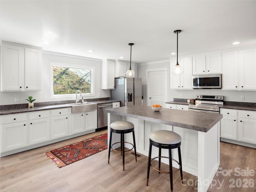 Brand new home in the heart of Fletcher offering space, flexibility, and a rare workshop opportunity. Situated on 0.67 acres and conveniently located between Asheville and Hendersonville, this newly installed home provides comfortable one-level living with room to spread out. The open floor plan connects the living, dining, and kitchen areas, creating a welcoming layout for everyday living and entertaining. The kitchen features a large island with seating, a stainless steel farmhouse sink, and a functional design that makes meal prep and gathering easy. The split-bedroom floor plan places the primary suite privately apart from the 2 additional bedrooms. In addition to the bedrooms, a versatile flex space with a closet, is ideal for a home office, guest room, hobby space, or additional sleeping area. Primary offers 2 linen storage areas and a tiled shower. One of the property’s most impressive features is the 1,600-square-foot workshop/garage with electricity. Whether you need space for tools, woodworking, vehicle storage, equipment, or a home-based business, this is a rare find with incredible potential.