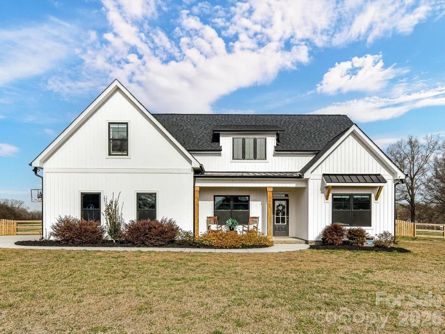 Welcome to this SPECTACULAR 5 bed, 3 bath, modern farmhouse built in 2022 that feels brand new.  Perfectly situated on a private 3 acre lot this home will check all of the boxes on your wishlist!  Up the driveway you'll first notice the undeniable curb appeal. Black framed windows, wood features and metal roof accents add to the charm. Past the impeccable landscaping and on to the rocking chair front porch you'll enter through the beautiful glass and wood front door. Upon entering the light filled entryway you will find two front bedrooms suitable for a home office, home gym or a first floor guest suite. The first floor full bathroom provides unlimited options for guests and family. 

Updated features including barn doors, updated lighting and impeccable tile add to the style and give the feeling that this is the one!  The open great room with a beautiful painted brick fireplace and shiplap detailing open to the large dining area and gleaming kitchen with island counter seating for 3 or more!  Stylish lighting, black hardware and Kitchen Aid appliances make entertaining effortless in this fabulous kitchen. The main floor primary bedroom boasts tray ceilings, a large walk-in closet and perfectly appointed bathroom. Dual sinks, fantastic accent tile and frameless glass shower provide every convenience. 

Upstairs an expansive loft area is a dream bonus space for your largest sectional, game tables and more! The original builder added a custom built closet in one of the rooms which is currently being utilized as a large 5th bedroom.  The additional spacious upstairs bedroom has a large adjoining playroom and walk-in closet offering endless options - that could even be used as an upstairs primary.  The expansive three acre flat lot boasts a fenced back yard, established and flourishing landscaping and privacy and serenity. Put your feet up on the covered back porch in complete relaxation as you take in the unbelievable sunset views! Septic permit is for 4 bedrooms and 8 occupants - permit attached.