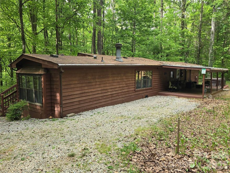 Tucked away on over 5.5 acres of serene woodland, this charming cabin-style retreat offers the perfect balance of privacy and convenience, just minutes from downtown Mooresville, NC. Currently operating as a successful income-producing Airbnb, the home features a unique “extendo” style manufactured design that provides a more spacious and distinctive layout than a typical single-wide. Inside, you’ll find a cozy living room anchored by a fireplace, while outside invites relaxation with a covered front porch, a back patio, and a peaceful hot tub setting surrounded by nature. Whether you’re seeking a quiet personal escape, an investment opportunity, or both, this one-of-a-kind property delivers comfort, character, and tranquility. Iredell county planning said you may be able to subdivide the property to get 3 additional lots. Each lot would require 100ft road frontage and have a minimum of 1 acre. Flag lots require 25ft road frontage. Buyer is responsible for getting info. from planning & zoning to subdivide or change use if buyer plans to. Home has been renovated. Some unpermitted work may have been done to the home. There is no road Maintenance Agreement in place.