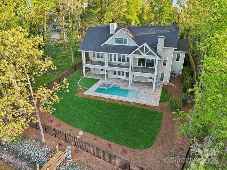 Experience luxury living at this stunning Cape Cod-style new construction home on the western shores of Lake Norman! Set on 0.47 acres w/ 100 ft of prime shoreline this property provides spectacular views of both sunrises & sunsets. The light gray cedar shake siding & grand wood front door create a timeless & inviting exterior. Inside the home boasts 4 bedrooms 4.5 baths & an open-concept design w/ vaulted ceilings & panoramic water views. Floor to ceiling windows flood the home w/ natural light highlighting the elegant white oak hardwood floors brushed brass hardware & gourmet kitchen w/ quartz countertops & GE Luxury series appliances. The luxurious primary suite on the main floor includes vaulted ceilings w/ shiplap detailing & a marble bath w/ dual sinks & closets. The walk-out basement featutes a second kitchen, fireplace, home theater, & flex space for a wine cellar, gym, or office. Outdoors enjoy an 18x16 pool & spa, putting green & 2 gas fireplaces for ultimate relaxation!