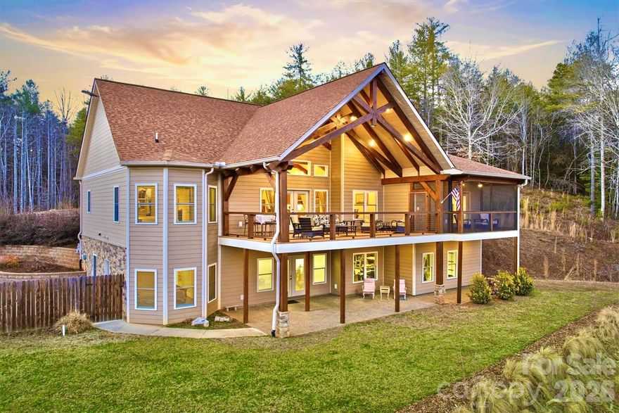 Grand luxury home at The Coves Mountain River Club, a 3,200-acre Blue Ridge Mountain gated community, on the Johns River.   Located on 4.3 acres, this home, with +/-7,000 sq ft under roof (including porches and unheated areas), was built for durability, longevity, and style. The foundation is pre-cast concrete by Superior Walls. Framing is 2 x 6 construction with an R-21 wall and R-39 roof of 30-year architectural shingles. The exterior facade is Hardie Board fiber cement.. ••• Open floor plan with vaulted ceilings constructed of true solid beams over an airy, spacious great room and kitchen. Engineered hickory floors w/lifetime warranty are nailed down. Stone fireplace w/gas logs and mantel constructed of 200+ yr old cypress, sourced from a historic New Orleans warehouse. ••• An ample granite peninsula and bar delineate kitchen from great room and dining area.  This spacious layout blends cooking and connection. Quarter sawn oak cabinets and granite counters extend into butler pantry. Stainless appliances include GE Cafe Series dual-fuel 6 burner range and double oven, Bosch dishwasher, and under-counter ice-maker. ••• Off the great room is a magnificent deck, overlooking the pastoral valley.  Supporting the deck and roof system, from ground to roof, are single, solid 10”x10” vertical beams. Massive scissor truss beams support the 2-story vaulted ceiling. The deck floor is composite, rails are wire cable, and the top rails are single continuous beams, on each side. ••• Your primary bedroom suite is a personal haven and retreat.  Relax on your private screened porch.  Cool blue walls and marble surfaces create a spa bathroom experience with a soaking tub, and walk-in shower. ••• An x-large mud+laundry room features a custom built alder bench and drawers with Manzanita burl root pegs, creating a rustic, but artistic, organized drop zone. A utility sink and durable tile floor are practical and easy to clean.  Above the 2-car garage is a large, finished, heated and cooled room (not included in Heated Living Area sq. footage), accessed via oak stairs in the garage. ••• Work from your home office or create a personal library in the large spare room, featuring custom built bookcases and desk. ••• Guests and family can choose from multiple bedrooms overlooking the valley. In the walk-out basement, 2 of the rooms have closets and are used as bedrooms by seller.  A large room that opens to the concrete stamped patio and back-lawn is used by seller as a home gym and music studio. The home’s septic system is permitted for 3 bedrooms. ••• The downstairs den/recreation-room has built-in bookcases and cabinets for tv and media equipment, a mini-fridge, and microwave. ••• A beautiful 16'x40' saline pool, surrounded by lush landscaping, a privacy fence, and 650 sq ft of concrete pool decking are your summertime oasis. ••• Park your UTV in the 941 sq ft basement workroom.  This versatile space is ideal for:
• In-law Suite
• Woodworking Shop
• Home Bar
• Game Room
• Wine Cellar
• Theater / Media Room
• Extra Storage
• Workout Room / Home Gym
• Kids playroom
Accessed from the basement, a concrete vault room is underneath the front porch; the ceiling is reinforced metal ceiling topped with the concrete porch floor; walls and floor are concrete; door is fireproof metal.
This magnificent 4.3 acre compound is centrally located in The Coves Mountain River Club, the South's premiere outdoor lifestyle community. Amenities include a grand post+beam clubhouse, fitness center, trail system, vineyard, dog park, pickleball courts, picnic pavilions, 5 miles of Johns River, kayak accesses, community garden, 2 equestrian centers and more.  30+ clubs and activity groups. ••• Minutes from Lenoir, Morganton, Blowing Rock and the Blue Ridge Parkway. Pisgah National Forest and Wilson Creek Wild & Scenic River area are just outside the gates.